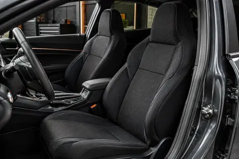 Deux housses noires en tissu technique installées sur les sièges avant d’un habitacle automobile anthracite