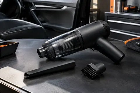 Aspirateur voiture BELIBUY noir mat avec buse et brosse, présenté dans un atelier urbain sobre