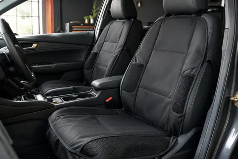 Deux protections de siège auto noires avec poches en filet, posées sur un siège anthracite.