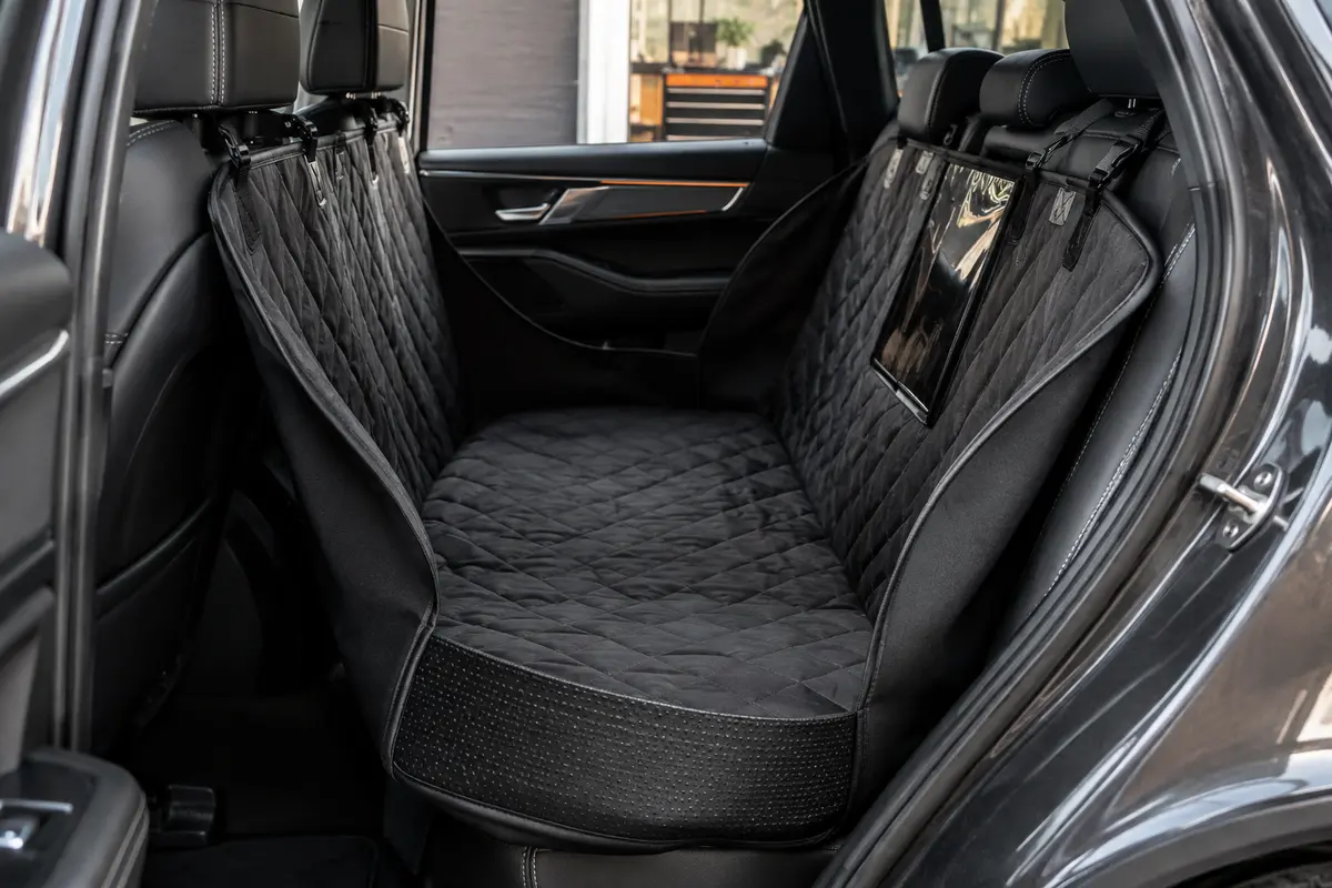 Housse de protection noire et blanche matelassée installée sur la banquette arrière d’une voiture