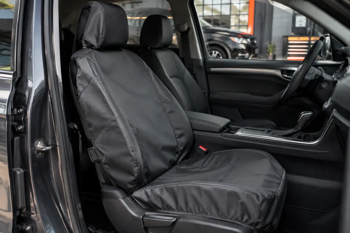 Housse individuelle en polyester installée sur un siège avant dans un intérieur automobile sobre.