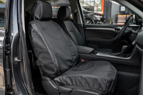Housse individuelle en polyester installée sur un siège avant dans un intérieur automobile sobre.